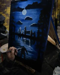 Close-up of guest painting a nighttime lake scene during Paint Night at Factory of Terror in Fall River MA
