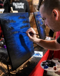 Man painting on canvas during Paint Night at Factory of Terror in Fall River Massachusetts