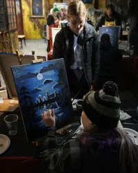 Guest painting a nighttime lake scene during Paint Night at Factory of Terror in Fall River Massachusetts